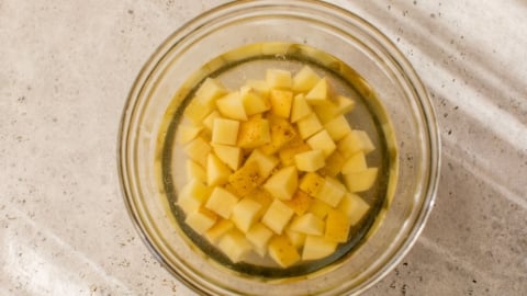 Potatoes soaking in bowl of water