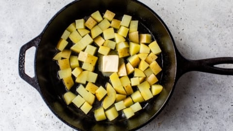 Potatoes in cast iron skillet with pat of butter