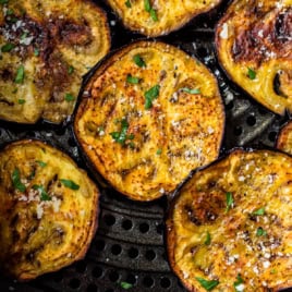 Cooked eggplant slices in air fryer basket