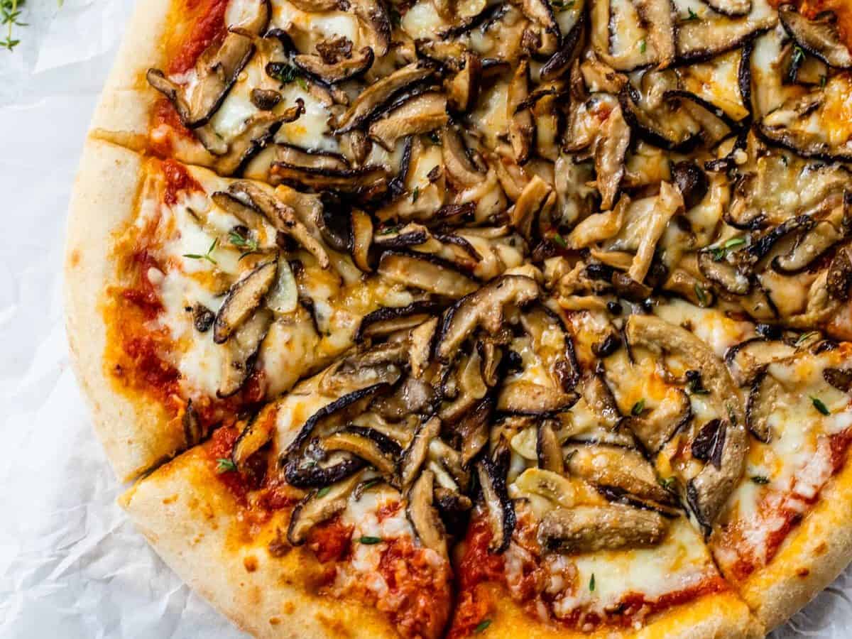 Overhead view of mushroom pizza cut into slices