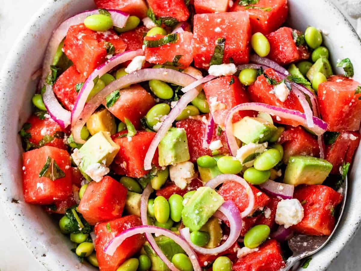 a bowl of watermelon salad with feta, mint, and red onions