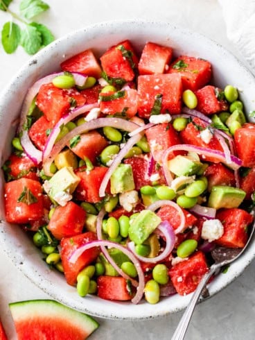 a bowl of watermelon salad with feta, mint, and red onions