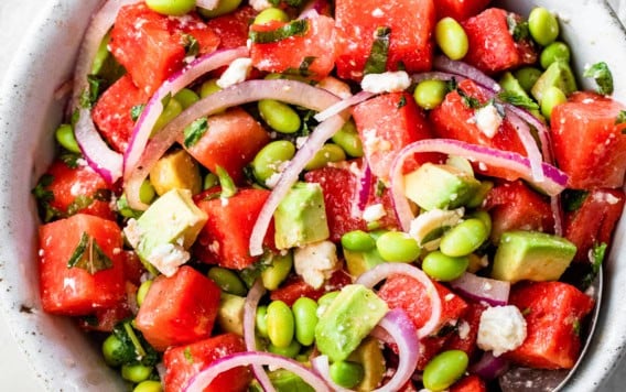 a bowl of watermelon salad with feta, mint, and red onions
