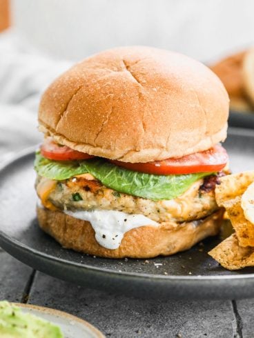 Ground chicken burger on plate with lettuce and tomato
