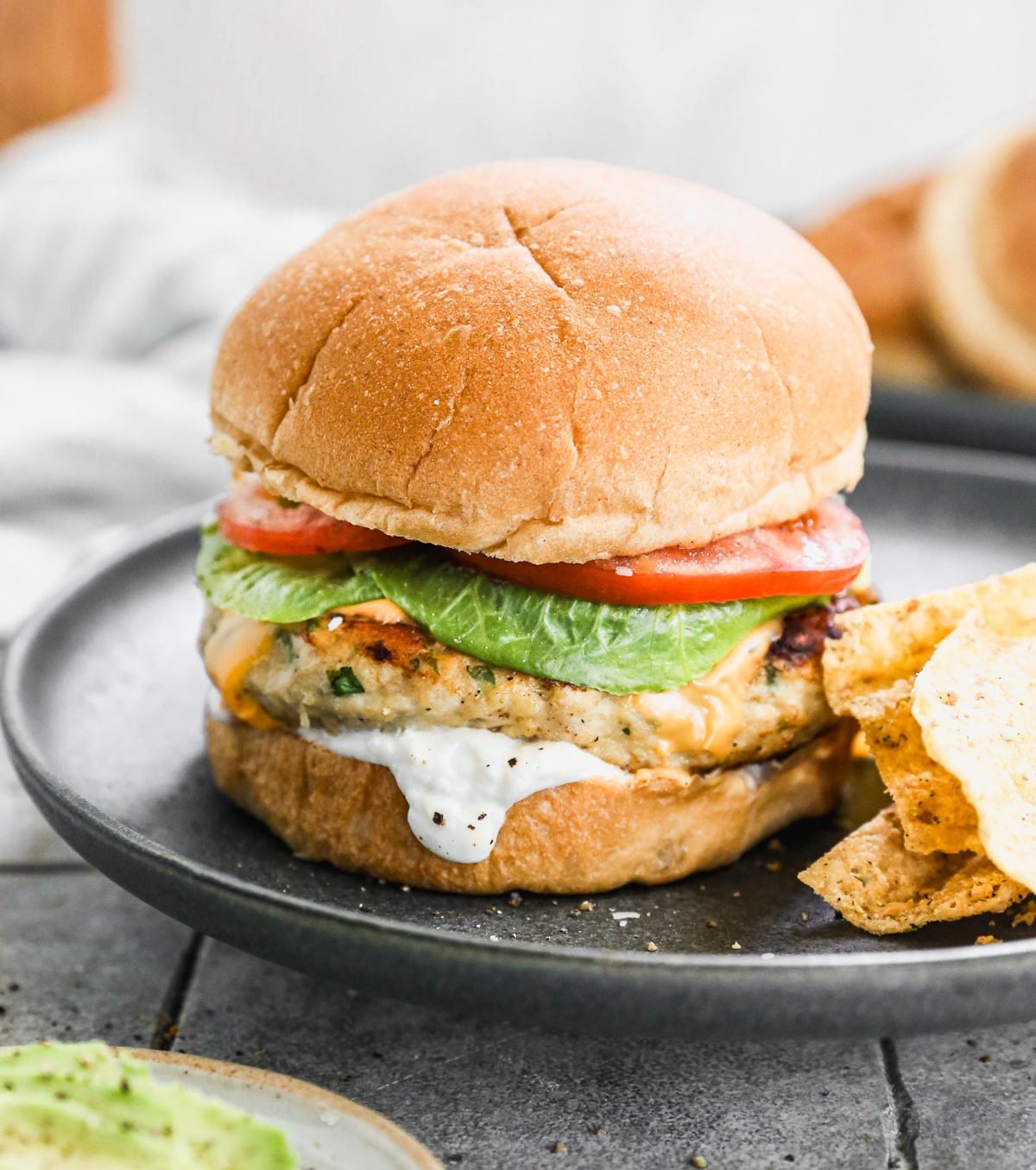 Ground chicken burger on plate with lettuce and tomato