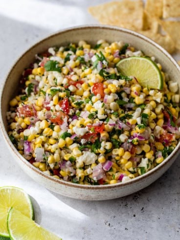 Bowl of corn salsa with lime wedge