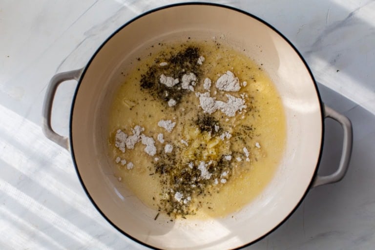 Flour sprinkled into butter in Dutch oven