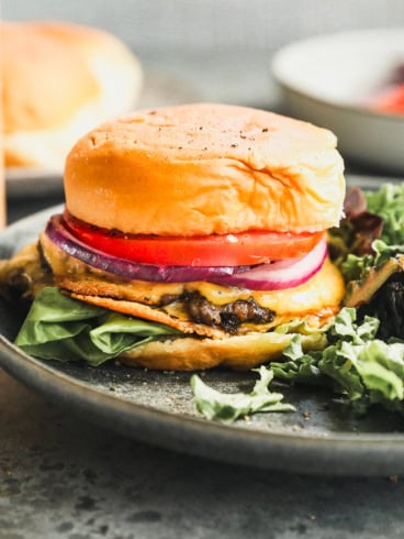 a double stacked smash burger on a bun with cheese, lettuce, and tomato