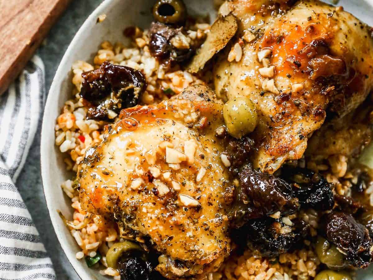 Overhead view of chicken marbella in bowl over rice
