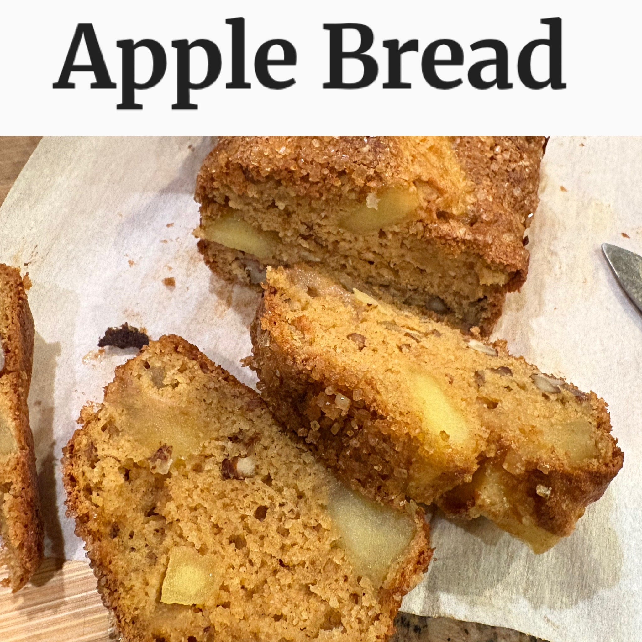 Sliced apple bread with chunks of apple and nuts on a parchment-lined board, with "Apple Bread" text above.