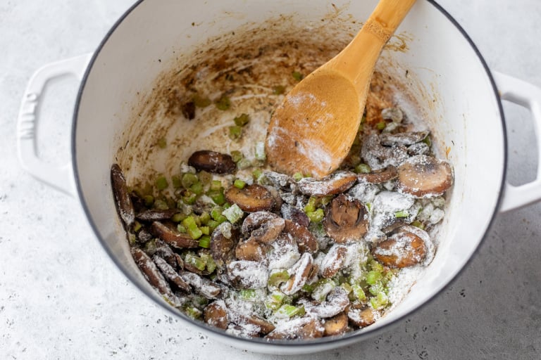 Flour added to mushrooms and celery in Dutch oven