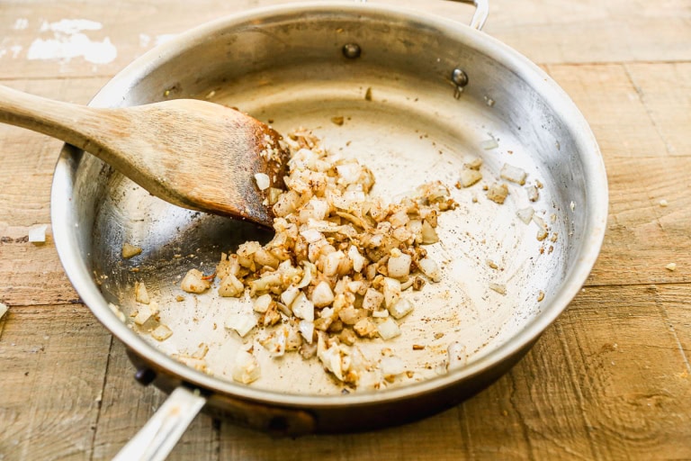 Cooking onions with spices in skillet