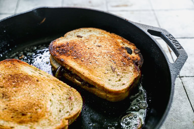 Patty melts cooking in skillet