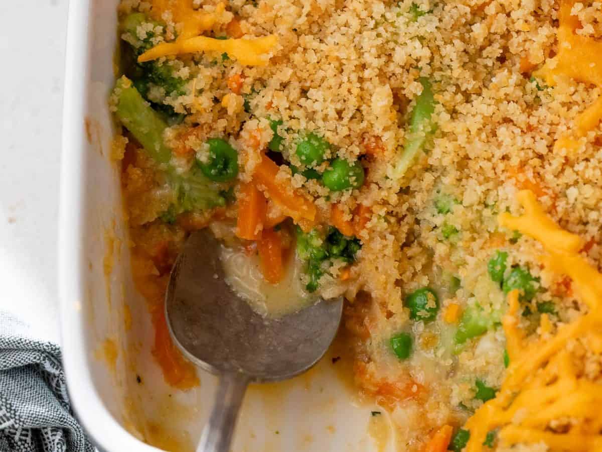 Vegetable casserole in baking dish with serving spoon