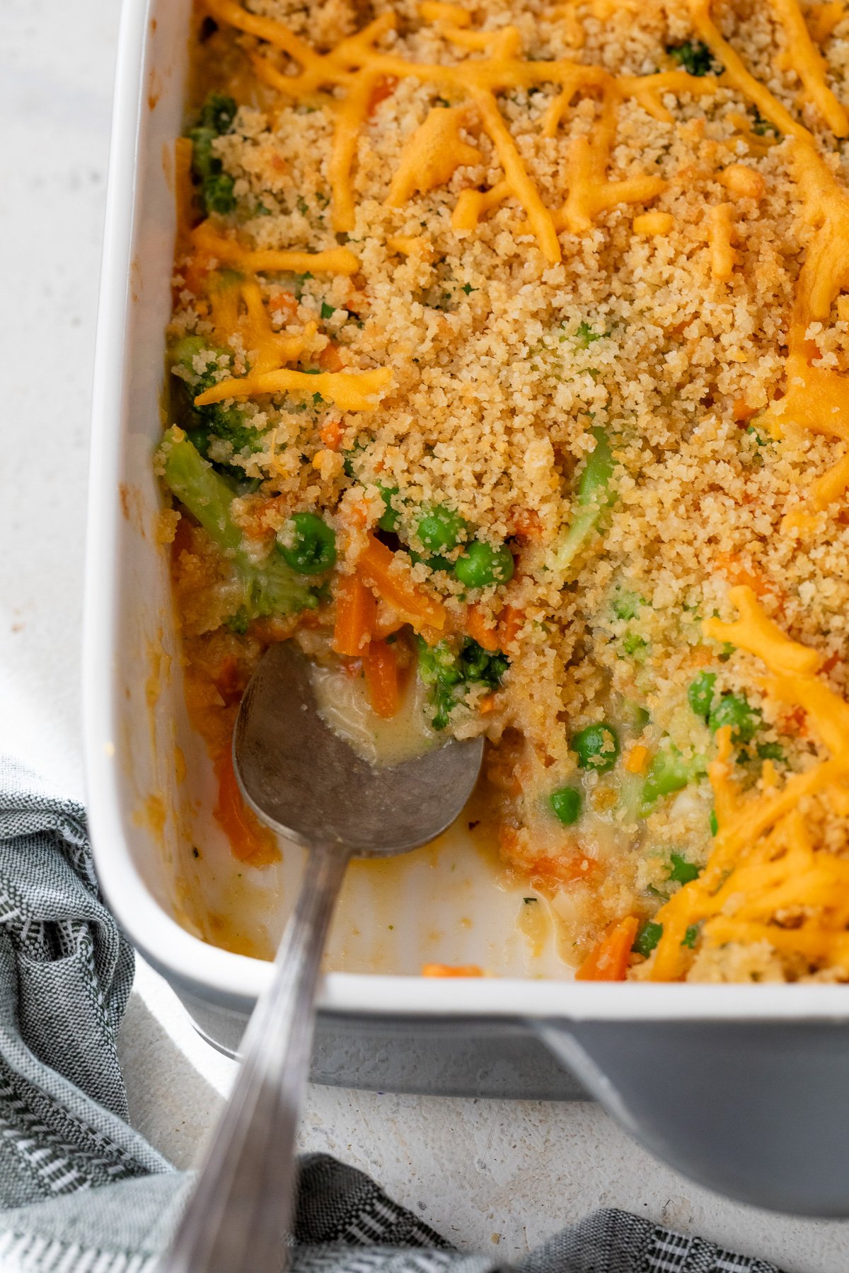 Vegetable casserole in baking dish with serving spoon