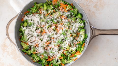 Flour sprinkled over vegetables in skillet
