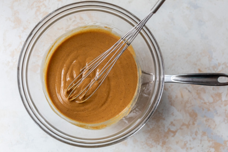 Liquid ingredients for peanut butter protein bars whisked in bowl
