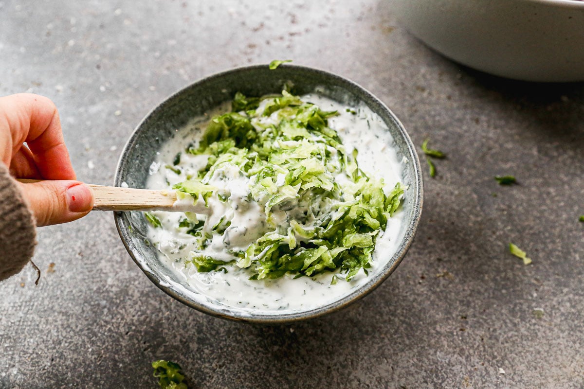 Stirring tzatziki sauce in bowl