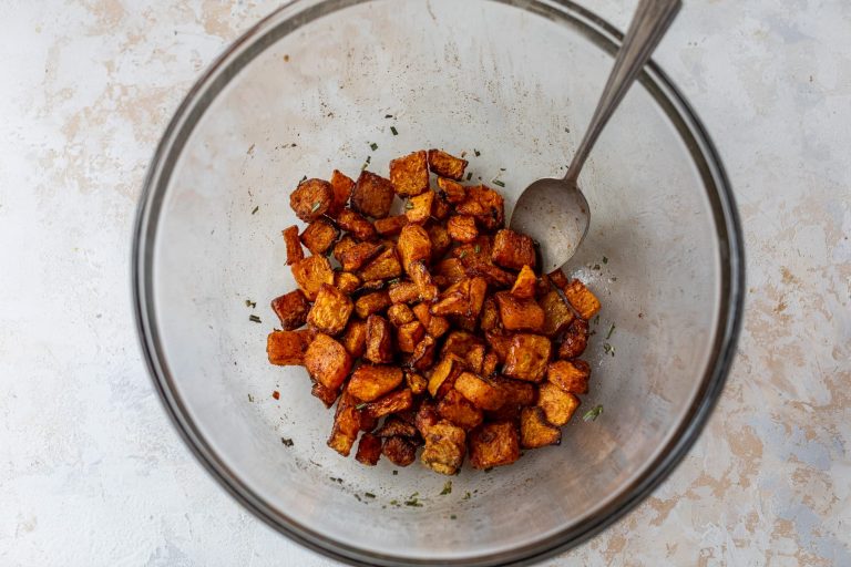 Air fryer butternut squash in glass bowl with seasonings