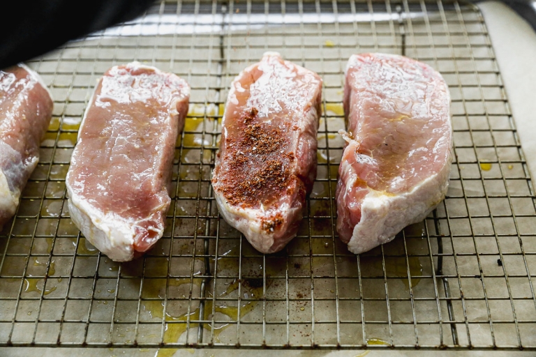 Pork chops on wire rack before seasoning