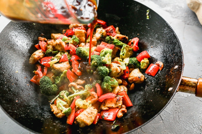 Pouring sauce into wok for cashew chicken