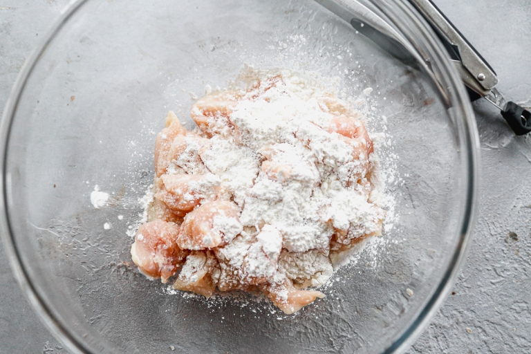 Chicken and cornstarch in glass bowl