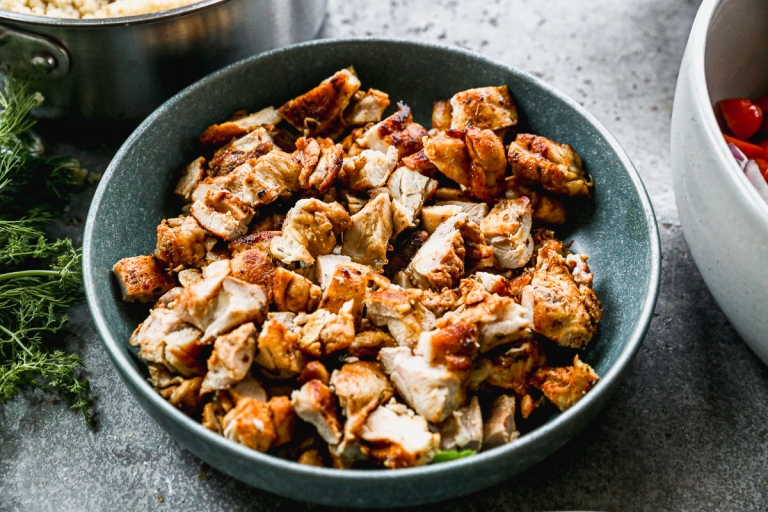 Greek chicken cut into pieces in bowl