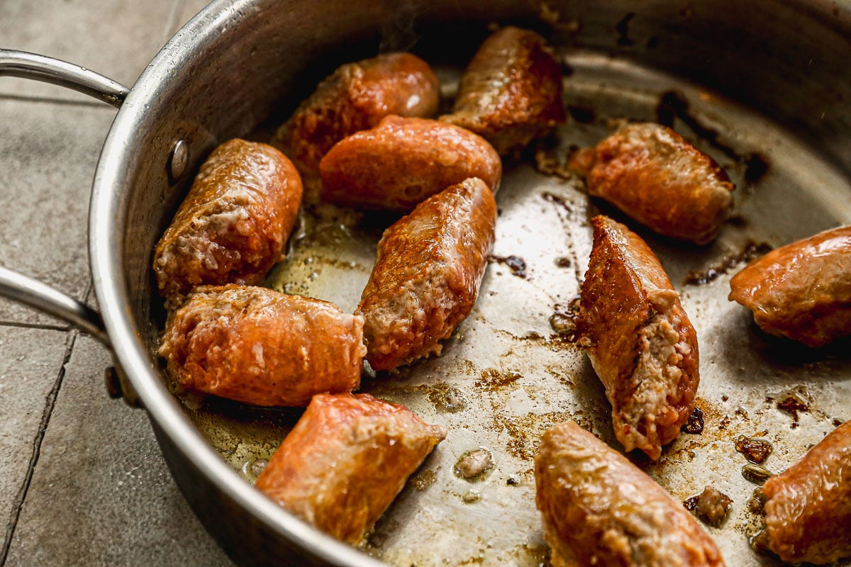 Sausages cooking in skillet