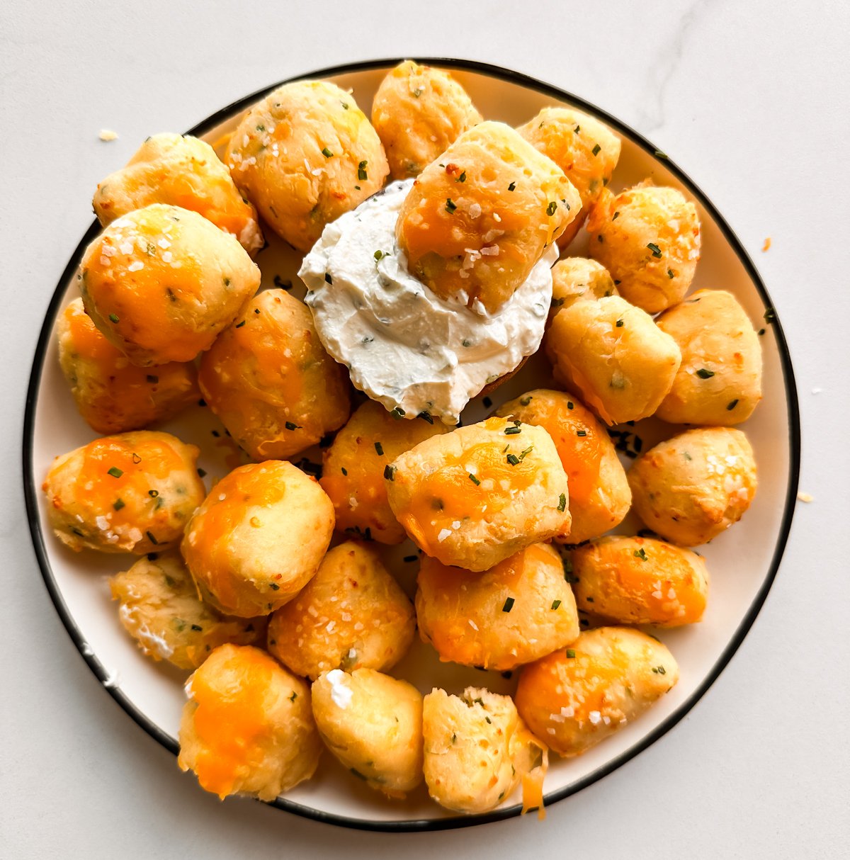 A plate of baked cheese bites made in the air fryer with dip
