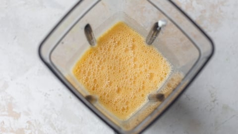 Top-down view of a blender with egg mixture