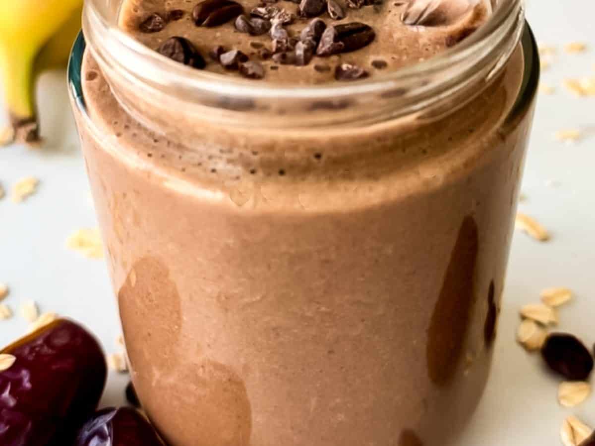 A glass jar filled with a creamy chocolate coffee smoothie