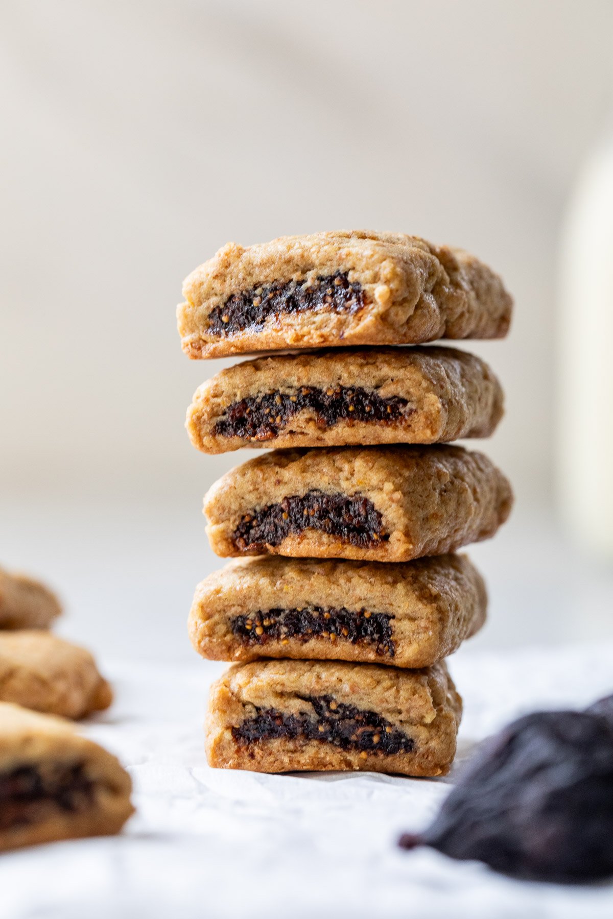 A stack of fig bars, each with a visible dark fig filling, on a light surface.