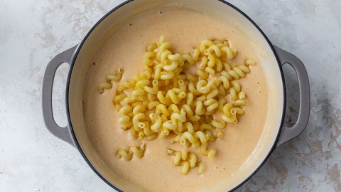 Cavatappi pasta added to skillet of cottage cheese mac and cheese sauce