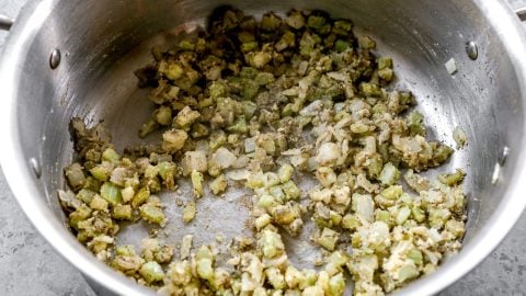 Celery and onion with flour in pot.