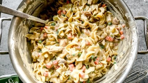 Stirring noodles and chicken into cream sauce.