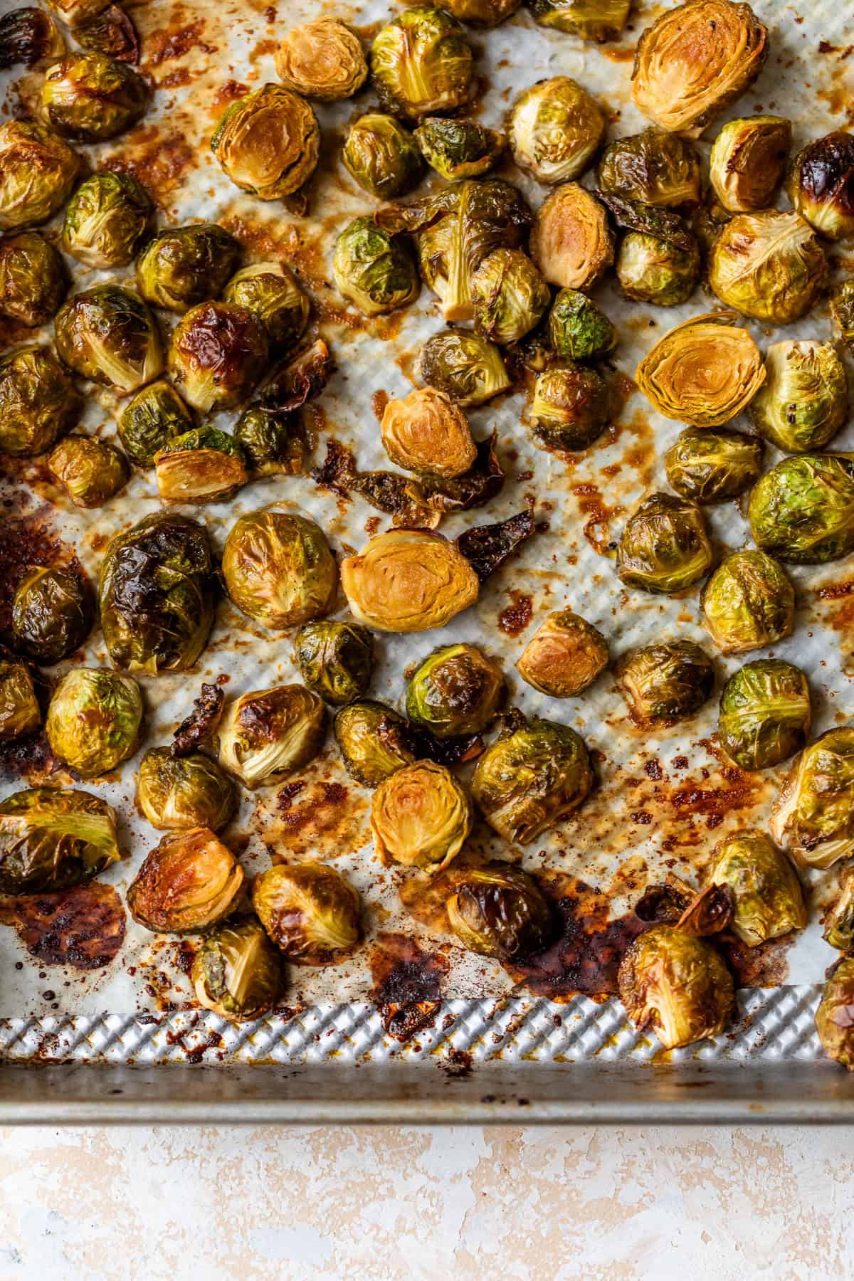 Caramelized Brussels sprouts on a baking sheet, golden brown and crispy with caramelized edges.