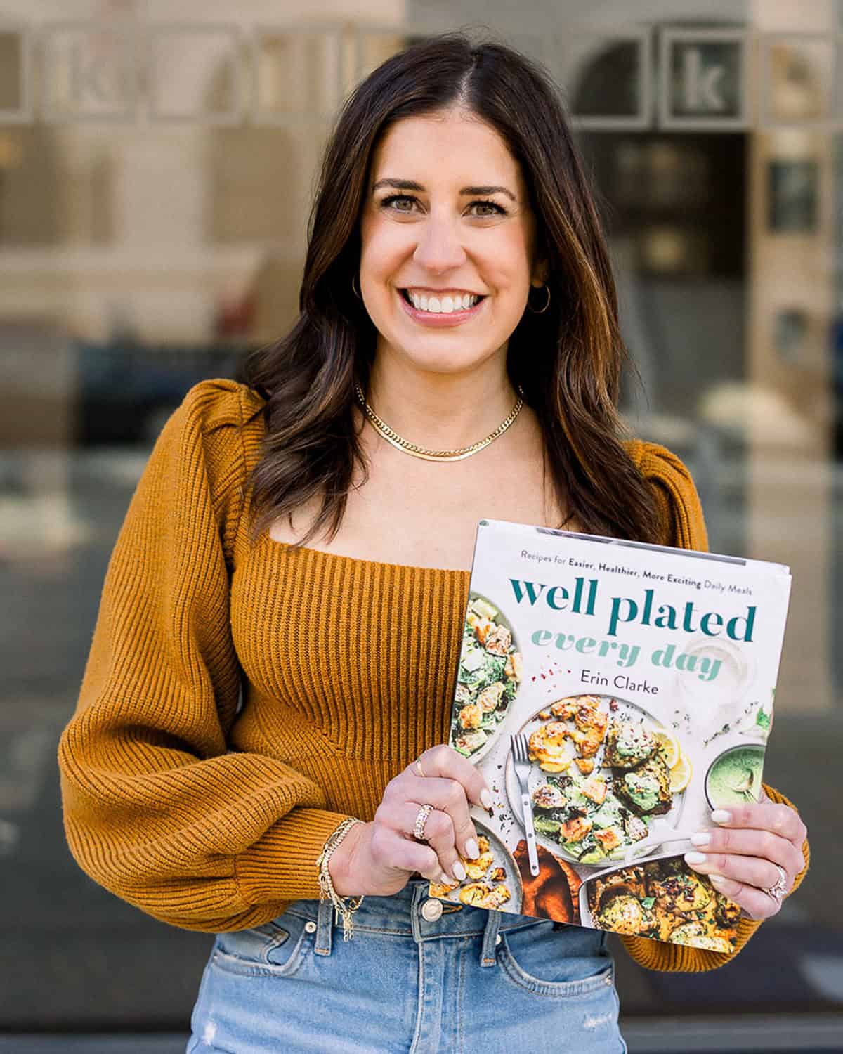 Erin Clarke holding Well Plated Every Day Cookbook