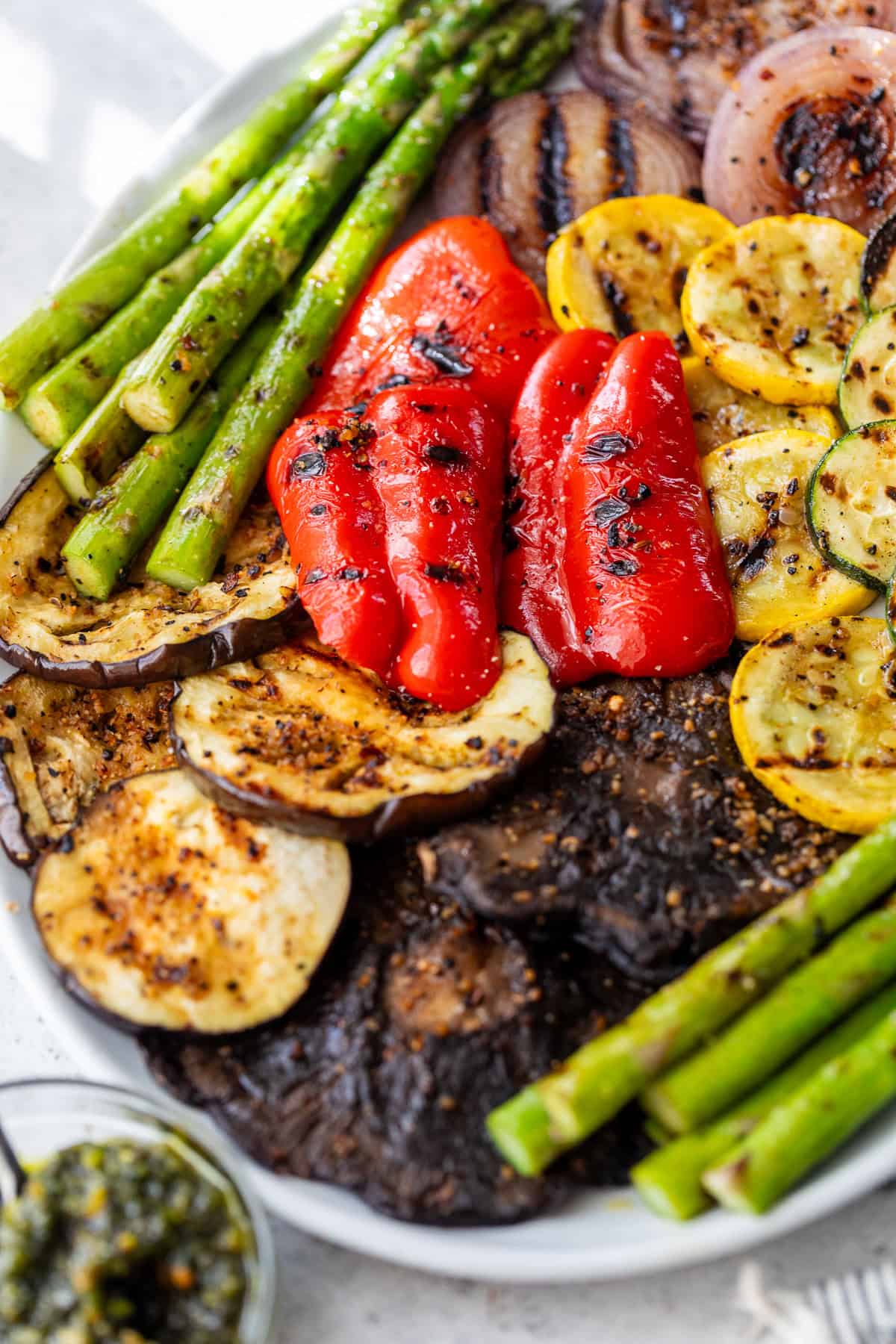 A platter of assorted grilled vegetables, including asparagus, bell pepper, zucchini, eggplant, and mushrooms.