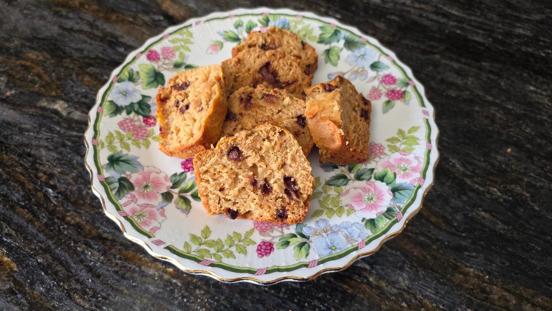 Five pieces of chocolate chip cake on a floral plate, set on a dark marbled countertop.