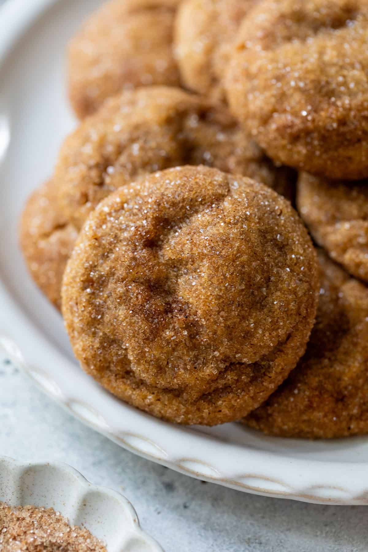 A plate of soft, round pumpkin spice cookies coated with cinnamon sugar.