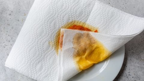 Paper towel blotting moisture from pumpkin puree spread onto plate.