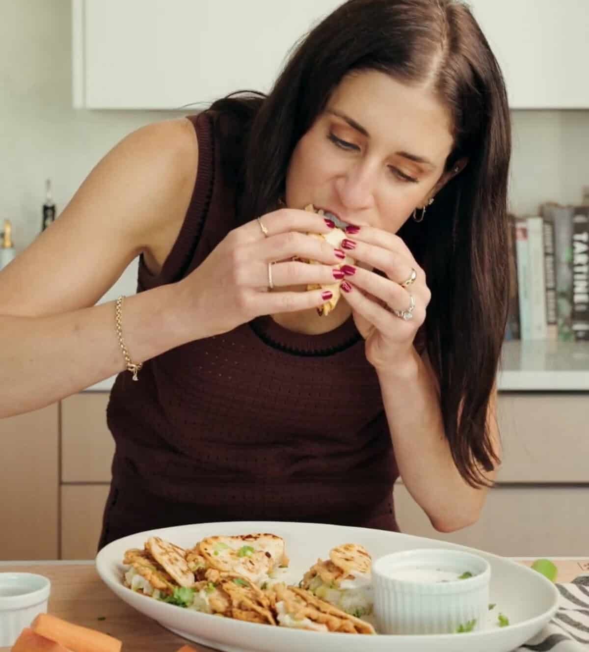 Erin Clarke eating buffalo chicken smash tacos