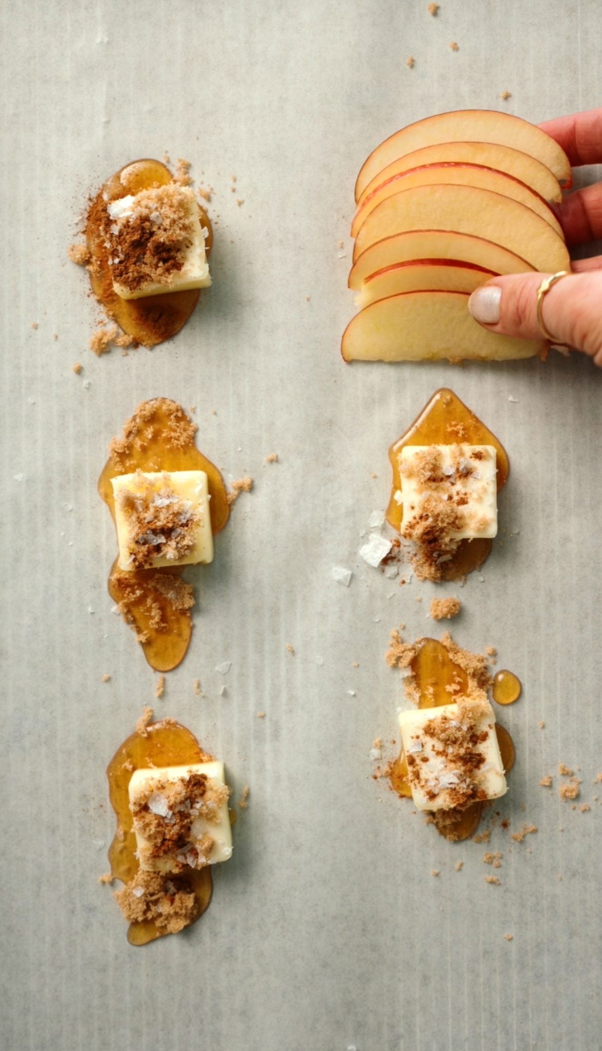 arranging apple slices over butter, brown sugar, honey, and cinnamon