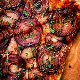 Red onion tart topped with fresh thyme leaves