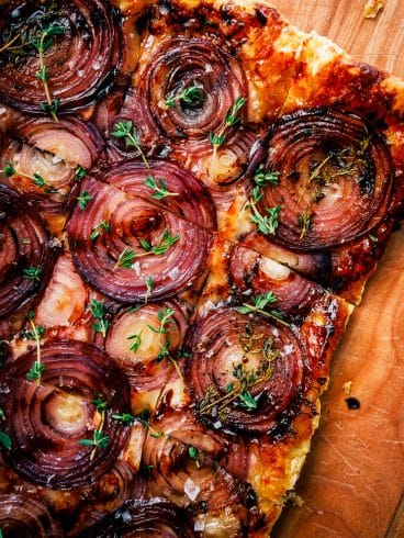 Red onion tart topped with fresh thyme leaves