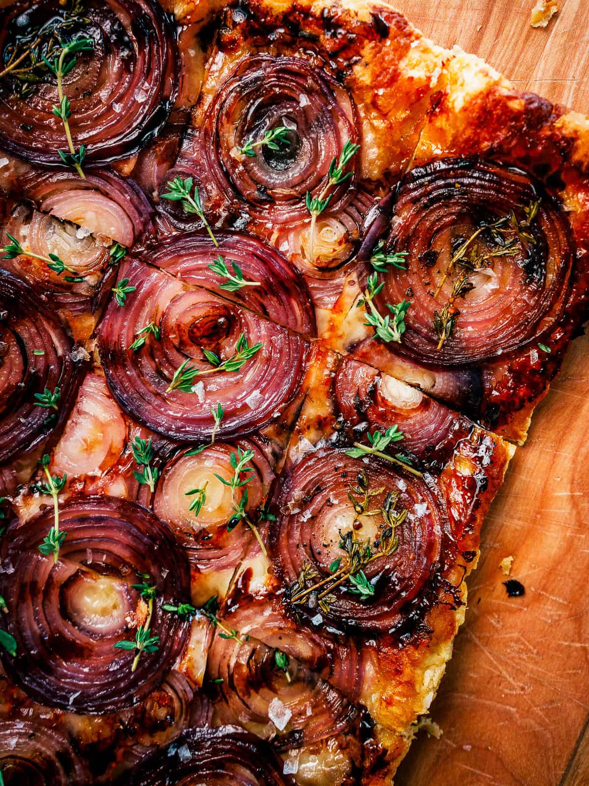 Red onion tart topped with fresh thyme leaves